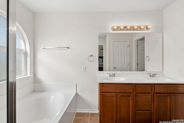 bathroom with tile patterned flooring, vanity, and a bathing tub