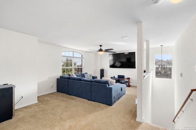 carpeted living room with ceiling fan and a textured ceiling