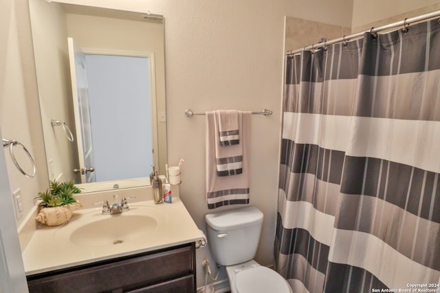 bathroom with a shower with curtain, vanity, and toilet