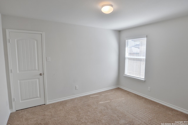 unfurnished room featuring light colored carpet