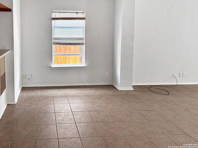 spare room with dark tile patterned floors