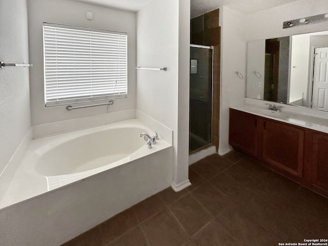 bathroom with tile patterned flooring, vanity, a textured ceiling, and independent shower and bath