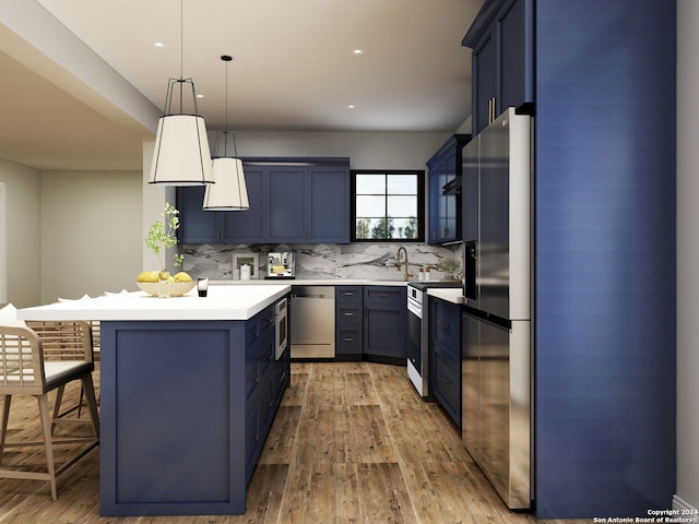 kitchen featuring stainless steel appliances, blue cabinetry, a kitchen bar, and decorative light fixtures