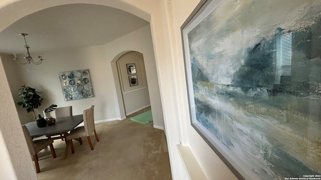 dining room with carpet flooring and a notable chandelier