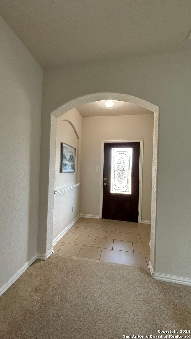 foyer entrance with light colored carpet