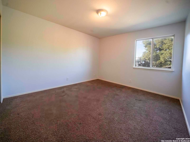 empty room with dark colored carpet