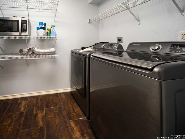 laundry area featuring washer and clothes dryer and dark hardwood / wood-style flooring