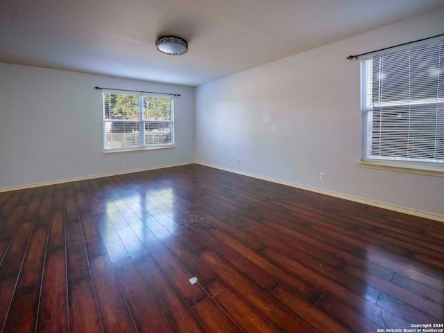 unfurnished room with dark wood-type flooring