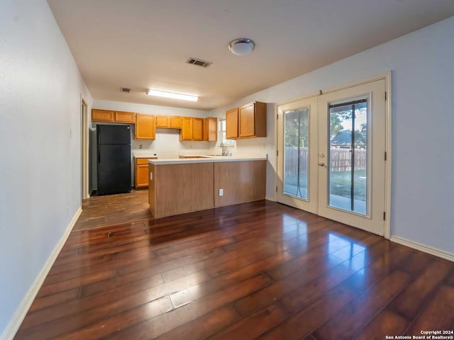 kitchen featuring black refrigerator, dark hardwood / wood-style floors, and french doors