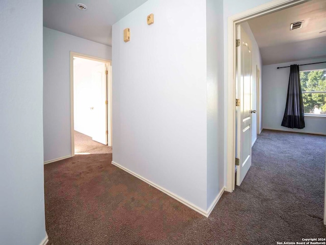 corridor featuring dark colored carpet