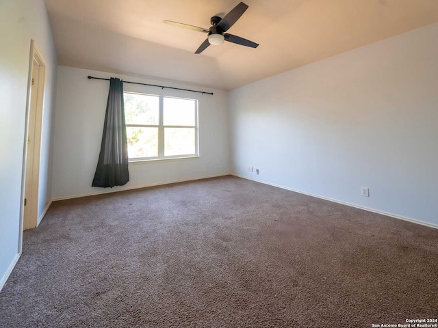 carpeted empty room with vaulted ceiling and ceiling fan