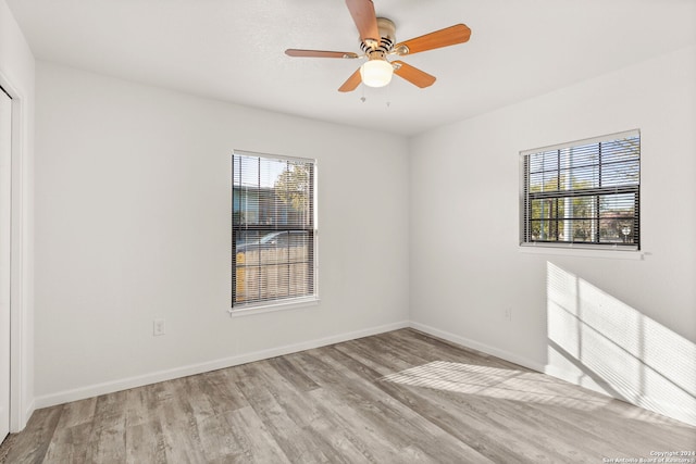 empty room featuring plenty of natural light, light hardwood / wood-style floors, and ceiling fan