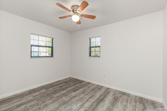 empty room featuring ceiling fan, a wealth of natural light, and light hardwood / wood-style flooring