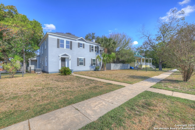 view of front of home with central air condition unit and a front yard