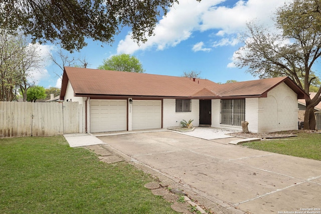 ranch-style home with a garage and a front lawn