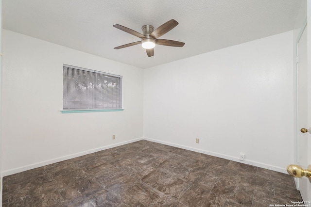 empty room with ceiling fan and a textured ceiling