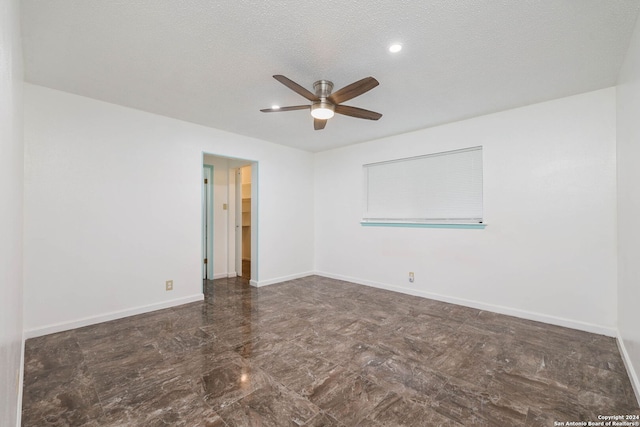 spare room with a textured ceiling and ceiling fan