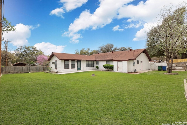 rear view of house featuring a lawn and a patio