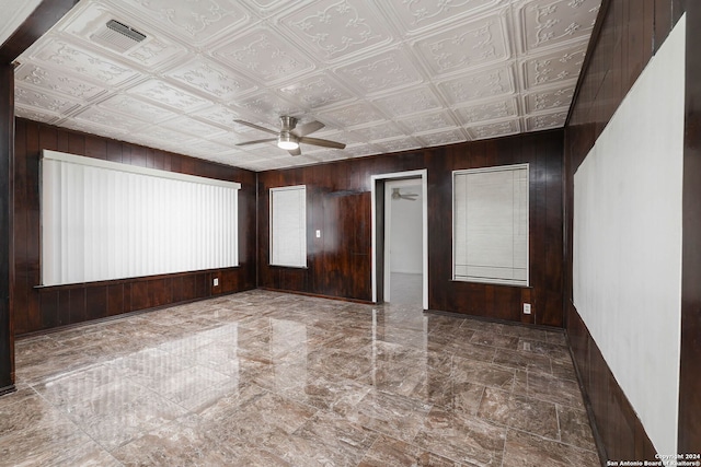 empty room with wooden walls and ceiling fan