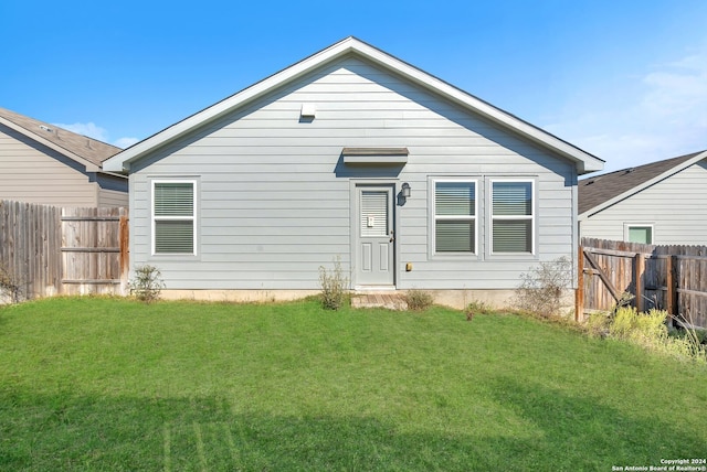 back of house with a lawn