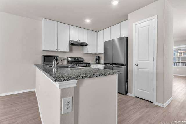 kitchen with kitchen peninsula, appliances with stainless steel finishes, light wood-type flooring, and white cabinets