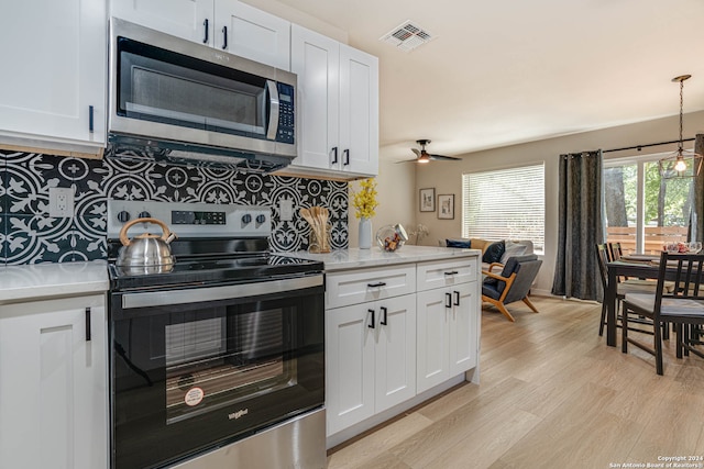 kitchen featuring light wood-type flooring, tasteful backsplash, stainless steel appliances, ceiling fan, and white cabinets