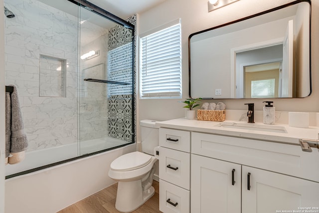 full bathroom featuring enclosed tub / shower combo, vanity, wood-type flooring, and toilet