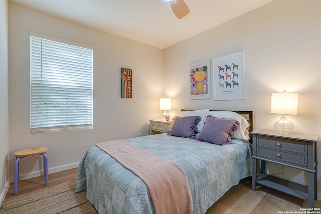 bedroom featuring ceiling fan, dark hardwood / wood-style flooring, and multiple windows