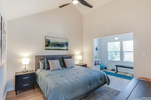 bedroom with ceiling fan, light wood-type flooring, and high vaulted ceiling