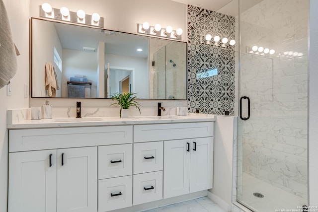 bathroom featuring a shower with door and vanity