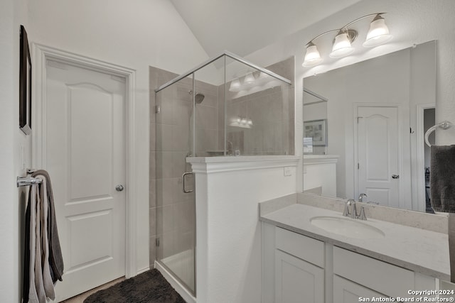 bathroom with vanity, an enclosed shower, and lofted ceiling