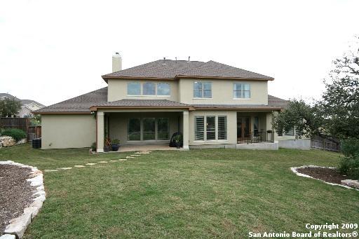 rear view of property featuring a patio and a lawn