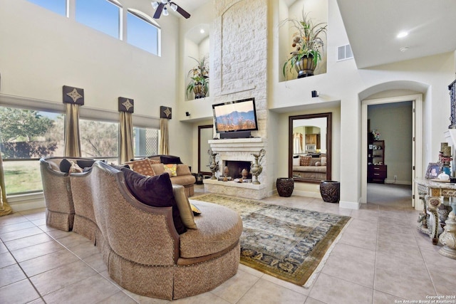 315 Dona Ana Cv, Helotes, TX 78023 - living room with a high ceiling, a ceiling fan, a fireplace, tile patterned floors, and arched walkways