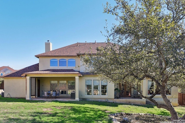 back of property with a lawn and a patio