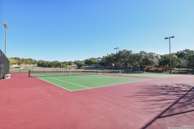 view of tennis court featuring basketball hoop