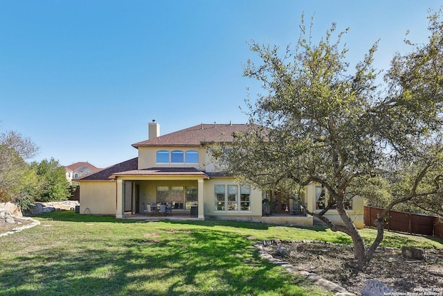 315 Dona Ana Cv, Helotes, TX 78023 - rear view of house featuring stucco siding, a patio area, a chimney, and roof with shingles