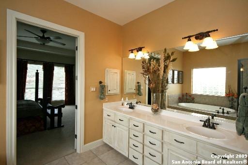 bathroom featuring tile patterned flooring, vanity, and a washtub