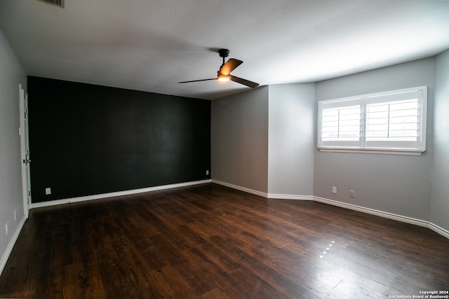 unfurnished room featuring ceiling fan and dark wood-type flooring