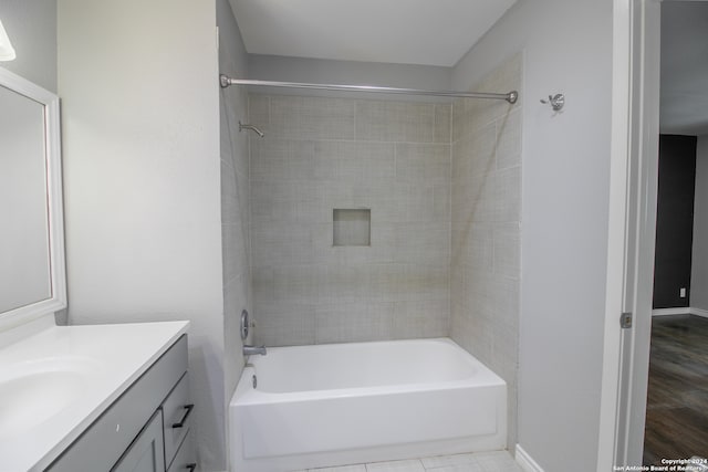 bathroom with vanity, tiled shower / bath, and hardwood / wood-style flooring