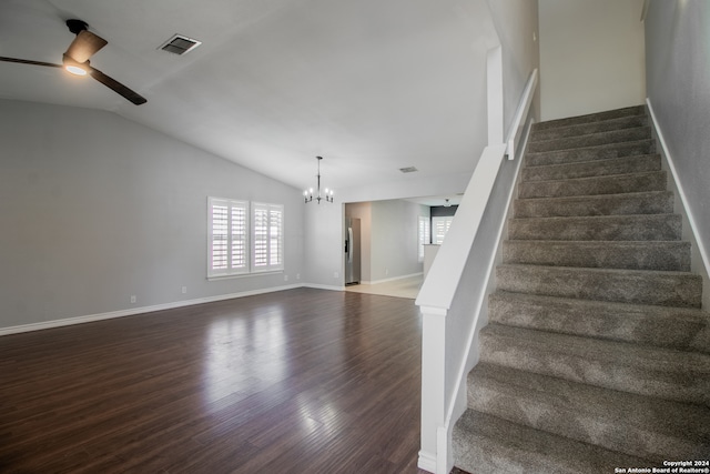 stairs with hardwood / wood-style floors, ceiling fan with notable chandelier, and vaulted ceiling