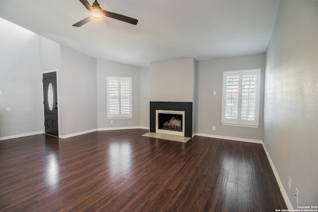 unfurnished living room with dark hardwood / wood-style floors, ceiling fan, and vaulted ceiling