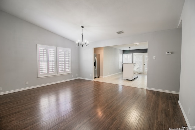 spare room featuring a chandelier, light hardwood / wood-style floors, and a wealth of natural light