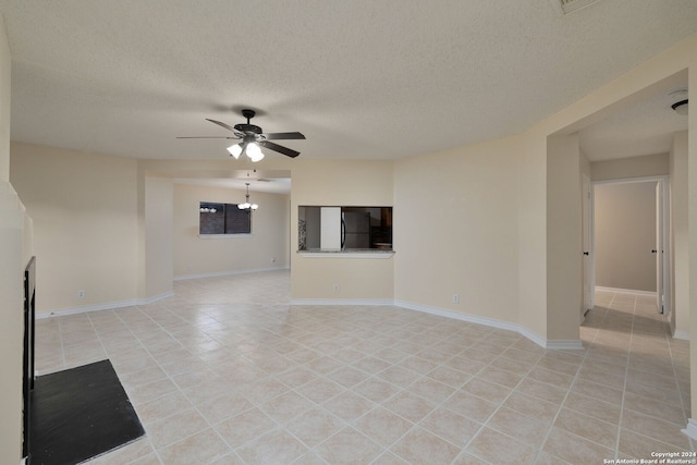 unfurnished living room featuring ceiling fan, light tile patterned floors, and a textured ceiling