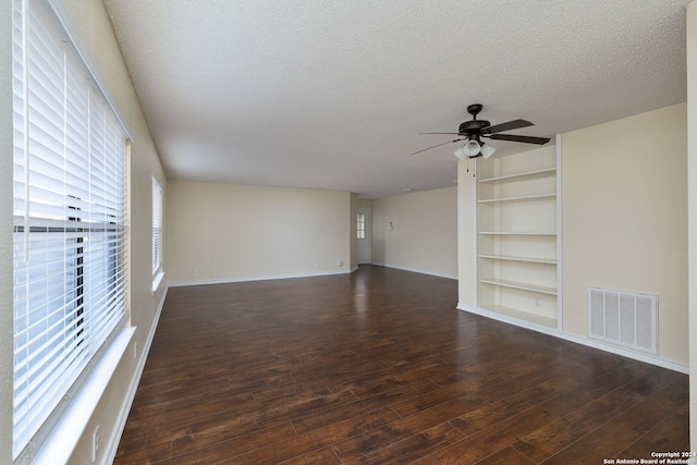 unfurnished room with a textured ceiling, dark hardwood / wood-style flooring, and ceiling fan