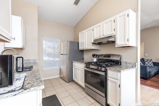 kitchen featuring light stone countertops, stainless steel appliances, light hardwood / wood-style flooring, white cabinets, and lofted ceiling