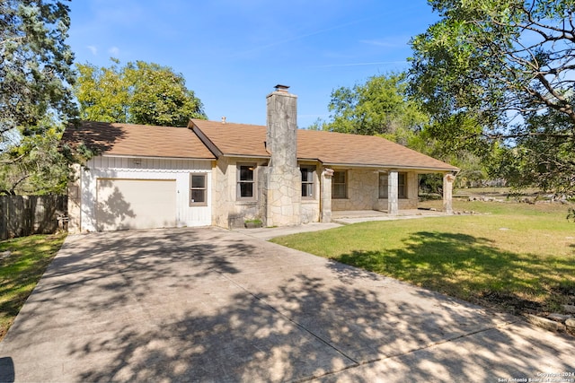 single story home with covered porch, a garage, and a front lawn