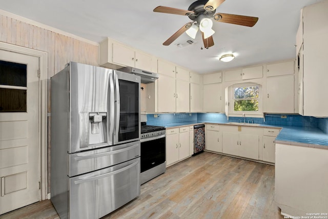 kitchen with backsplash, light wood-type flooring, stainless steel appliances, and cream cabinets