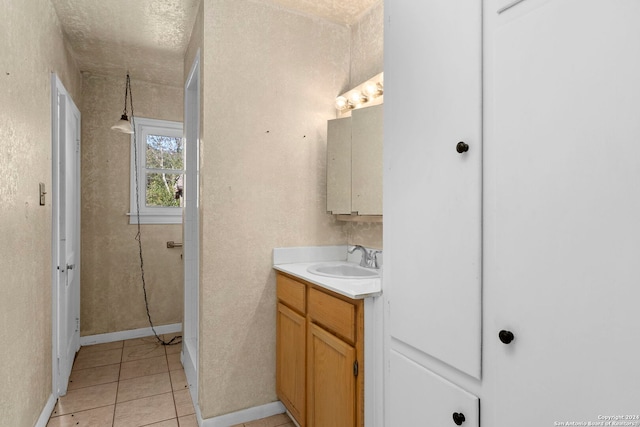 bathroom with tile patterned flooring, vanity, and a textured ceiling