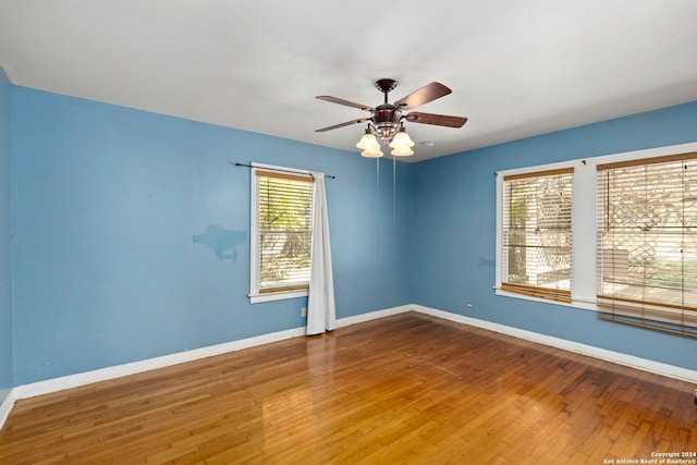 empty room with hardwood / wood-style floors and ceiling fan