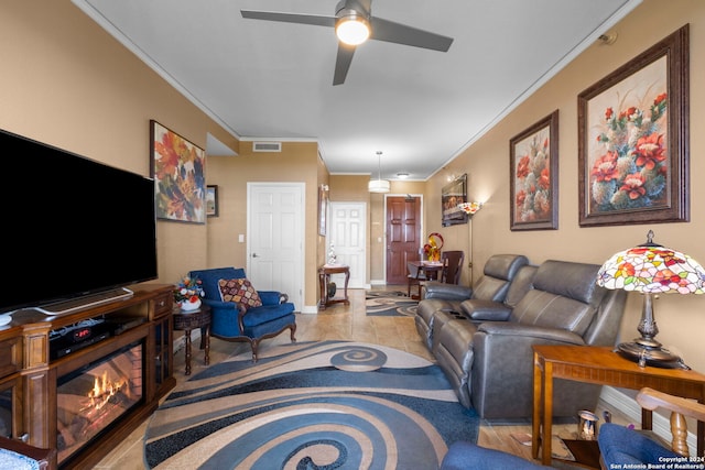 living room with crown molding, ceiling fan, and light tile patterned flooring